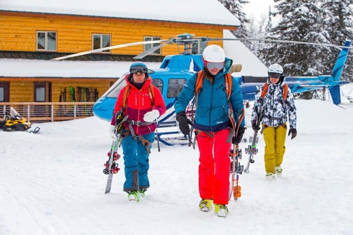 A group of skiers walk away from a helicopter after a day of heli skiing at Tordrillo Mountain Lodge.